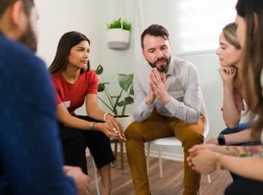 Man in his 30s asking for help at a rehab meeting