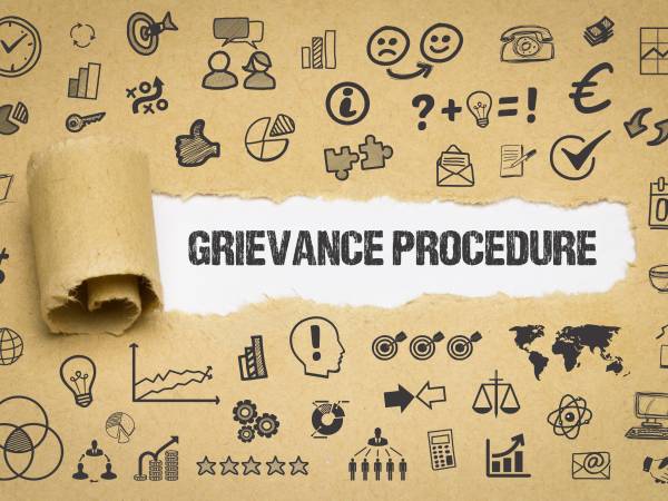 Grievance Procedure coming out of a torn up paper with lots of icons on it.