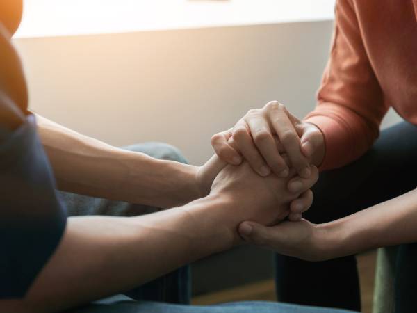 Psychologist sitting and touch hand young depressed asian man for encouragement 