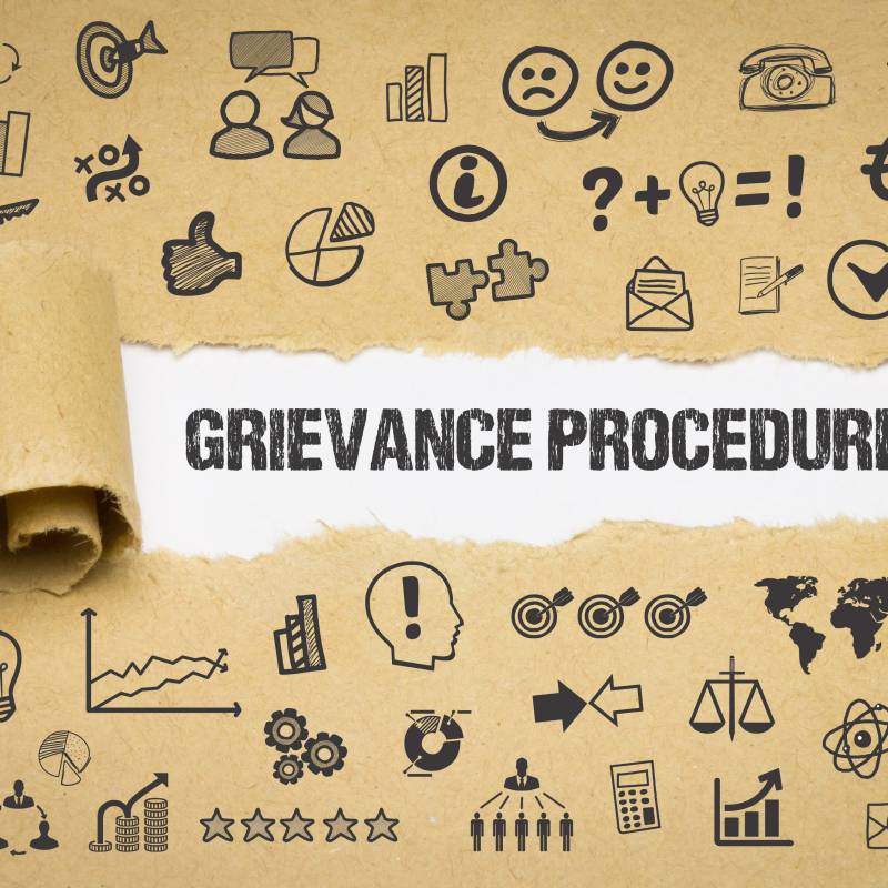 Grievance Procedure coming out of a torn up paper with lots of icons on it.