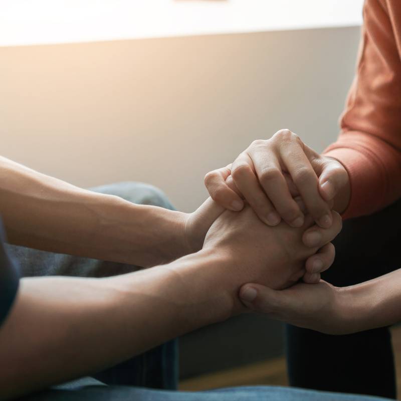 Psychologist sitting and touch hand young depressed asian man for encouragement 