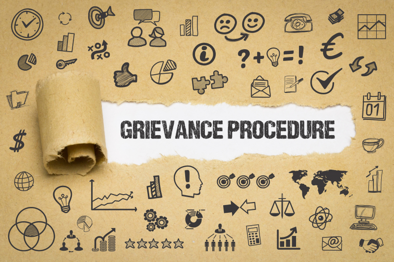 Grievance Procedure coming out of a torn up paper with lots of icons on it.